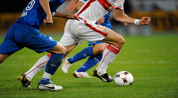 Football players battle for the ball, partial view